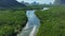 Aerial drone shot fly tracking a boat on a river, the mangrove forest of Phang Nga bay, Thailand