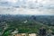 aerial drone shot over gurgaon showing monsoon clouds with light rays falling on ground crowded with homes houses, sohna