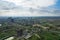 aerial drone shot over gurgaon showing monsoon clouds with light rays falling on ground crowded with homes houses, sohna