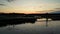 Aerial drone shot of a people walking on a bridge over a lake at sunrise, sunset