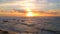 Aerial drone shot of silhouetted birds flying in front of setting sun at sunset over beach in Portugal