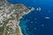 Aerial drone shot of south Capri coastline with faraglioni crag with luxury yachts in Tyrrhenian sea
