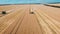 Aerial drone shot of a three combines harvesters working day in big a field. FHD