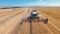 Aerial drone shot of a three combines harvesters working day in big a field. FHD