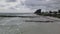 Aerial drone shot traveling over water towards jetty and dock looking down a coastline