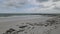 Aerial drone shot turning away from the sand to reveal sky and ocean waves