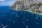 Aerial drone shot view of southern coastline of Capri Islan in Tyrrhenian sea with luxury yachts