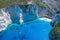 Aerial drone shot of Zakynthos Navagio beach with observation deck on cliff and yachts in summer