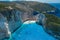 Aerial drone shot of Zakynthos Navagio beach with tourists with cruise ship in blue Ionnian sea