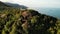 Aerial drone top view of exotic paradise tropical coastal cliff with volcanic stones covered with green jungle