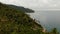 Aerial drone top view of exotic paradise tropical coastal cliff with volcanic stones covered with green jungle