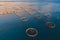 Aerial drone top view of sea fish farm cages and fishing nets, farming dorado, sea bream and sea bass, feeding the fish a forage,