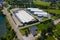 Aerial drone on trucks and logistic center. Warehouse aerial. Modern logistics center, white van and trailers standingon ramp