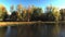 Aerial drone video in mid-air panning from right to left over the river revealing the colorful trees of Autumn