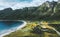 Aerial drone view above Storvika beach and ocean with mountains above village landscape