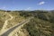 Aerial drone view of autumn landscape sunny day in spring in northern Extremadura, Spain, with road, trees, plants and rocks