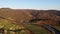 Aerial Drone View: autumn mountains with forests and river, meadows and hills in sunset soft light. Carpathian Mountains