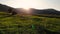 Aerial drone view Behind silhouette of man standing near tent on grass meadow with mountains and raising arms