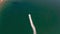 Aerial drone view of boat approaching tenby bay beach during a summer day.