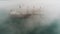Aerial drone view of cargo ship and cranes in morning fog in the harbor. Sea port Varna, Bulgaria