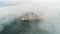 Aerial drone view of cargo ship and industrial cranes in fog in the sea harbor Varna, Bulgaria
