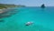 Aerial drone view circling around island hopping boat moored in shallow water in turquoise blue Cadlao lagoon. El-Nido
