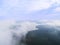 Aerial Drone view clouds over the green forest and lake. Low lying cloud. Aerial view of over tropical rainforest. Above the cloud