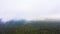 Aerial Drone view clouds over the green forest and lake. Low lying cloud. Aerial view of over tropical rainforest. Above the cloud