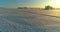 Aerial drone view of cold winter landscape with arctic field, trees covered with frost snow and morning sun rays over