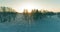 Aerial drone view of cold winter landscape with arctic field, trees covered with frost snow and morning sun rays over