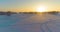 Aerial drone view of cold winter landscape with arctic field, trees covered with frost snow and morning sun rays over