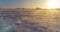 Aerial drone view of cold winter landscape with arctic field, trees covered with frost snow and morning sun rays over