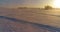 Aerial drone view of cold winter landscape with arctic field, trees covered with frost snow and morning sun rays over