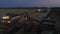 Aerial drone view of the combine harvester with lights works in night wheat fields.