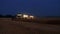 Aerial drone view of the combine harvester with lights works in night wheat fields.