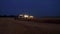 Aerial drone view of the combine harvester with lights works in night wheat fields.