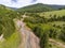 Aerial drone view, forest road near small flooded mountain river