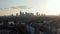 Aerial drone view of large city against bright sky. Drone flying towards group of skyscrapers downtown. Skyline of