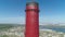 Aerial drone view of large red and white chimney without smoke at sunny day