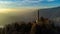 Aerial drone view of a lighthouse over Lake Como skyline with sunset light