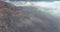 Aerial drone view morning view to misty over autumn forest mountains with open pit mine in a quarry mining industry