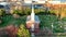 Aerial Drone View of an Old Church and Cemetery Surrounded by Refinery Tanks