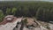 Aerial drone view of old demolished industrial building among forest. Pile of concrete and brick rubbish, debris, rubble