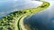 Aerial drone view of path on dam in polder water from above, landscape and nature of North Holland, Netherlands