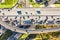 Aerial drone view of road interchange or highway intersection with busy urban traffic in modern city during sunny day. Traffic jam