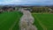 Aerial drone view of spring landscape a road among blossoming cherry alley near village and green fields. Germany