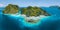 Aerial drone view of tropical Shimizu Island steep rocks and white sand beach in blue water El Nido, Palawan