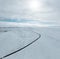 aerial drone view Uphill road landscape in winter at Iceland. Asphalt road with sideways full of snow during winter with