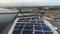 Aerial drone view of waterfront warehouse covered in solar panels