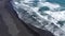 Aerial drone view of waves rushing to the shore on black volcanic sand. Atlantic Ocean, Iceland